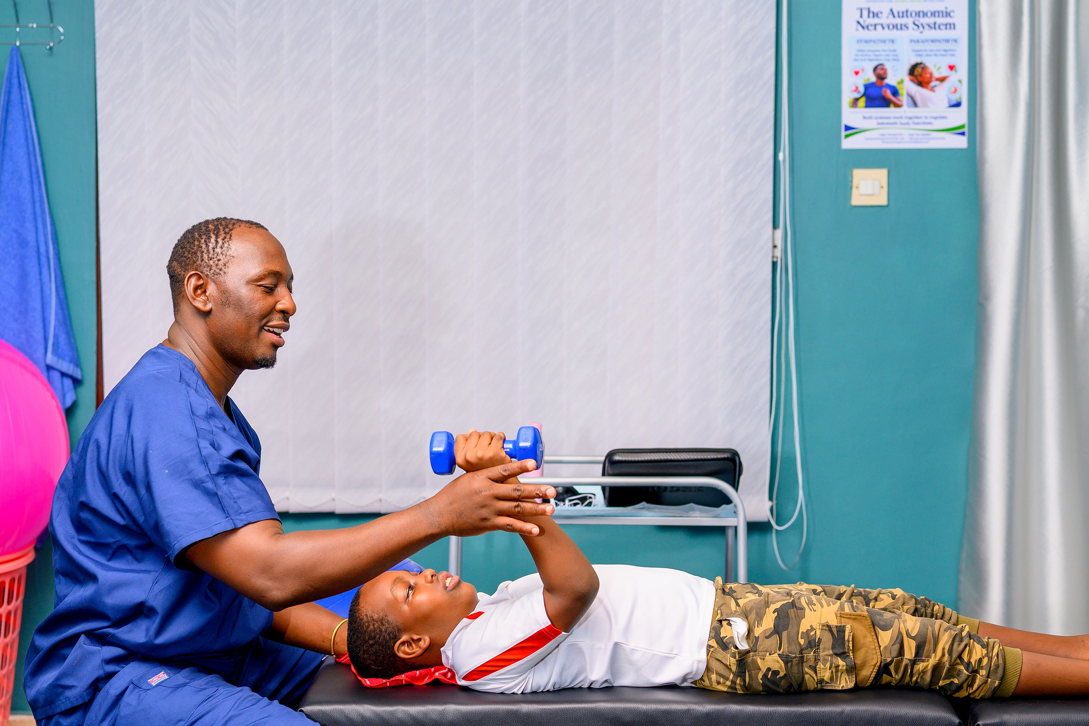 A practitioner guiding a patient through an arm exercise with a dumbbell